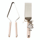 Cake Server Heart set includes a metal cake server and spatula with light pink, heart-shaped handles featuring small black hearts at the tips. The spatula has a cake charm and bow accent. Available sizes: standard.