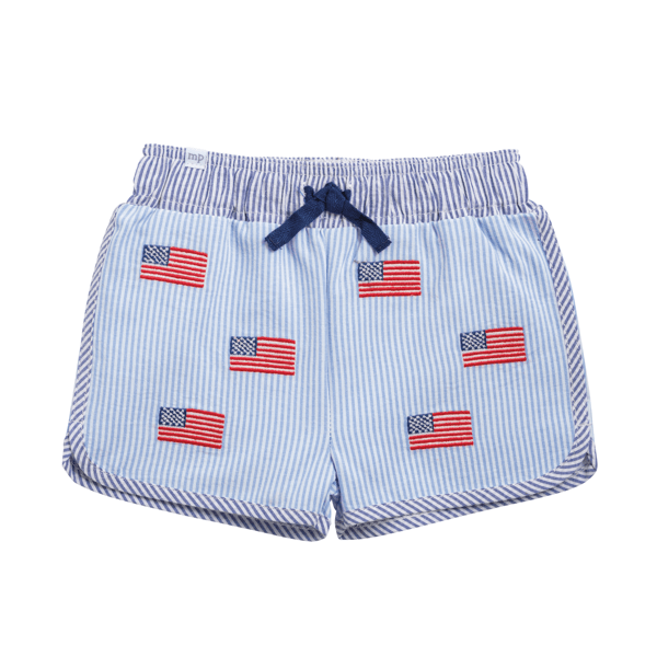 Light blue and white seersucker swim trunks with embroidered flag patches, elastic waistband, navy drawstring. Sizes S-XL.