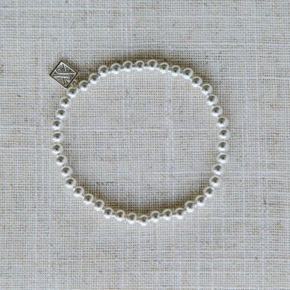 Nickel-free silver bracelet with pearls and a square metallic charm. Available in sizes S, M, and L.