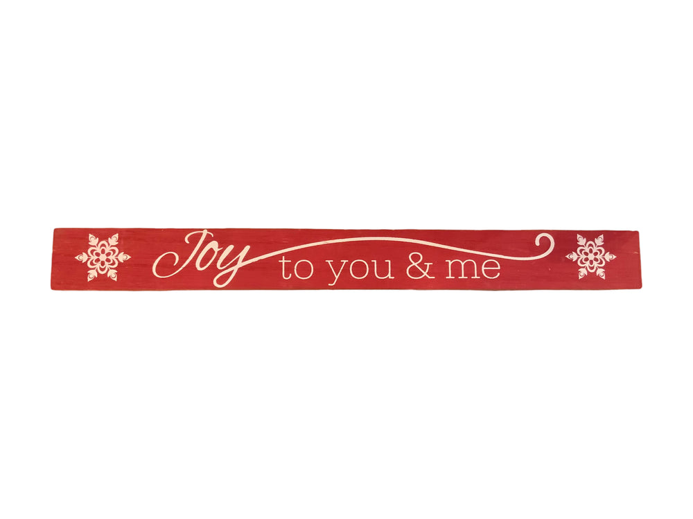 Red rectangular wood Christmas sign with white “Joy to you & me” text and snowflake accents.