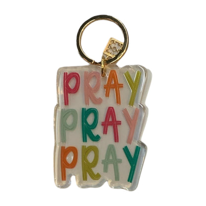 Clear acrylic keychain with "PRAY" repeated three times in bold colors, gold keyring. Size: 2"x1".