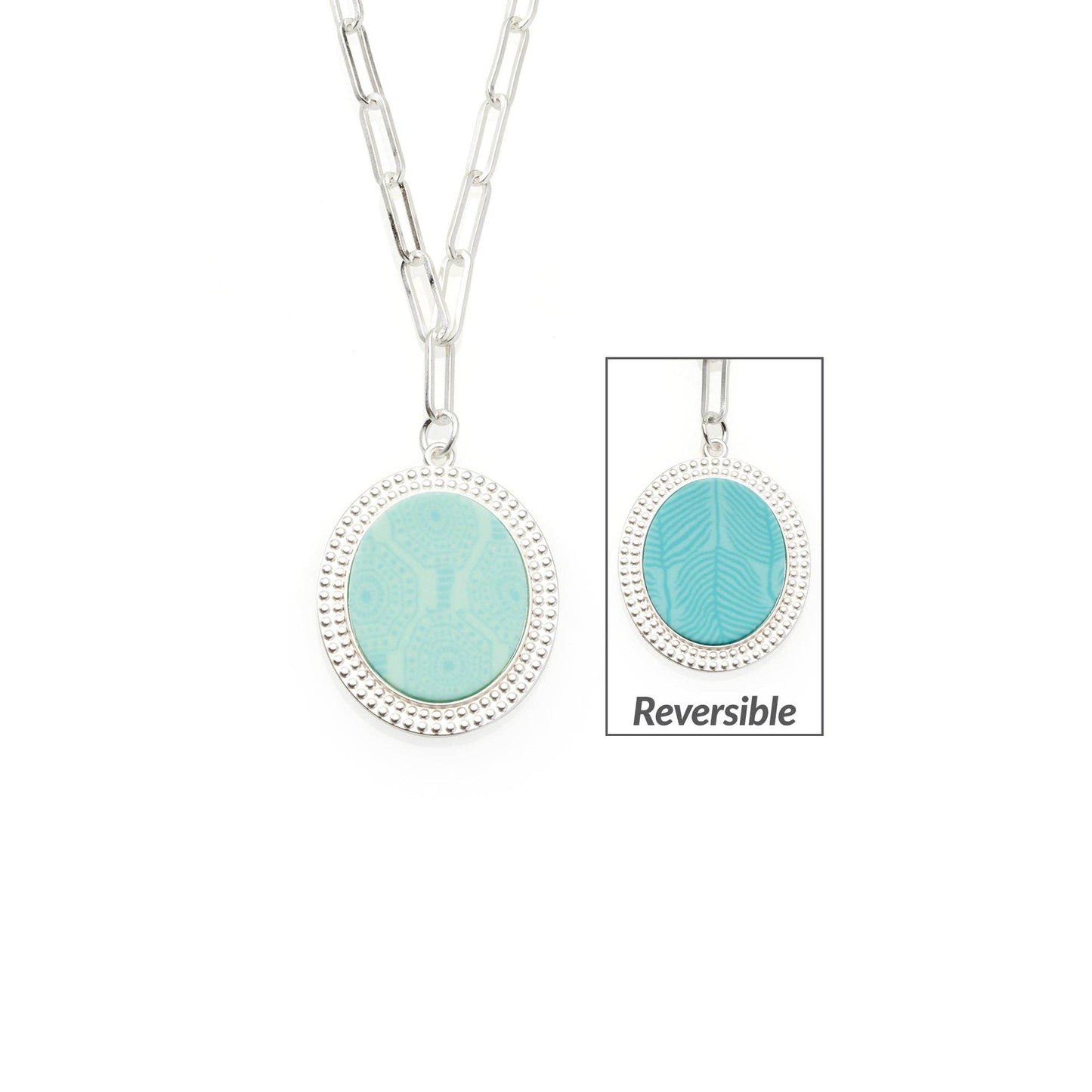 The Seaside Green Reversible Link Medallion Necklace features an oval charm with Maui Blue textured pattern on one side and Seaside Green geometric design on the other, framed by a beaded silver edge. Size: One size adjustable.