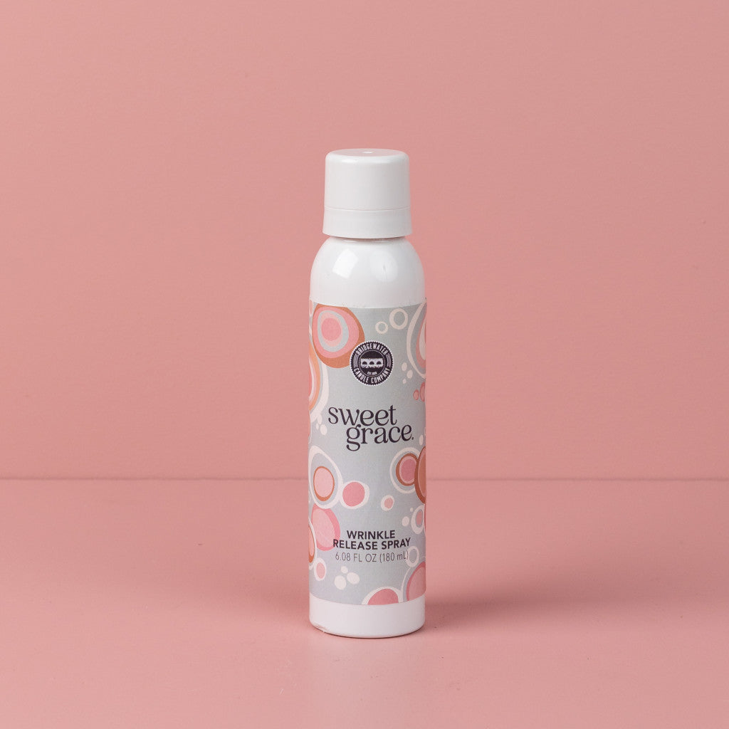 Sweet Grace Wrinkle Release Spray can with white cap, pink and beige label; freshens fabrics, eliminates odors. Available in multiple sizes.