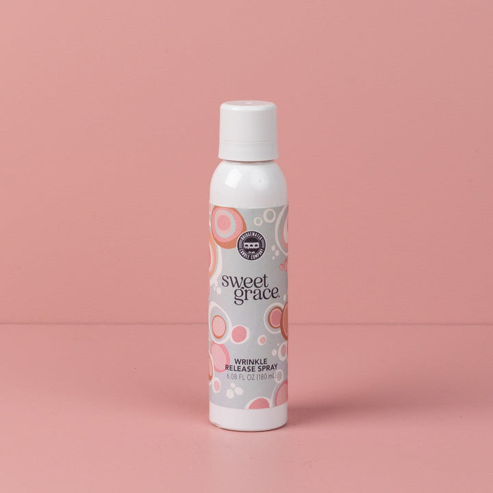 Sweet Grace Wrinkle Release Spray can with white cap, pink and beige label; freshens fabrics, eliminates odors. Available in multiple sizes.