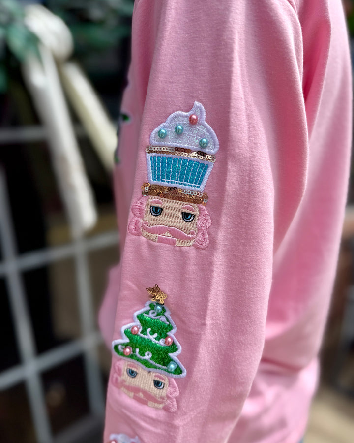 Holly Jolly Sweatshirt with pink sleeves, embroidered cartoon faces in cupcake and Christmas tree hats, decorated with beads and sequins. Available in sizes S–XL.