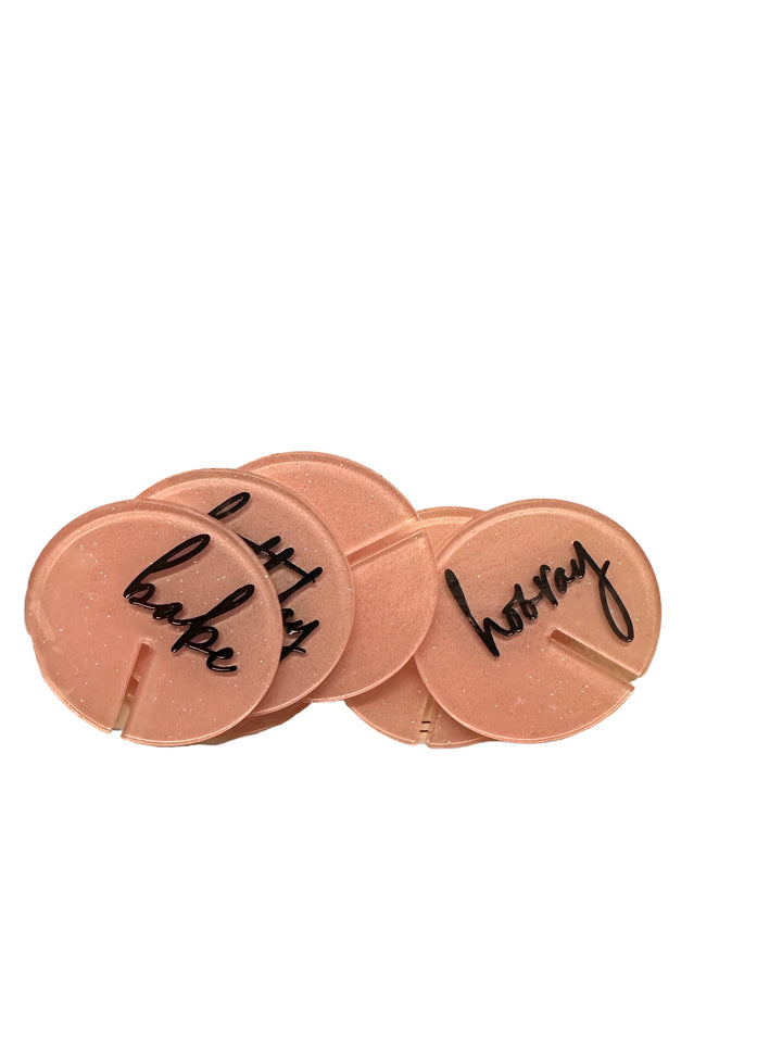 Set of five round pink acrylic drink markers with black handwritten words, available in various sizes; perfect for birthdays.