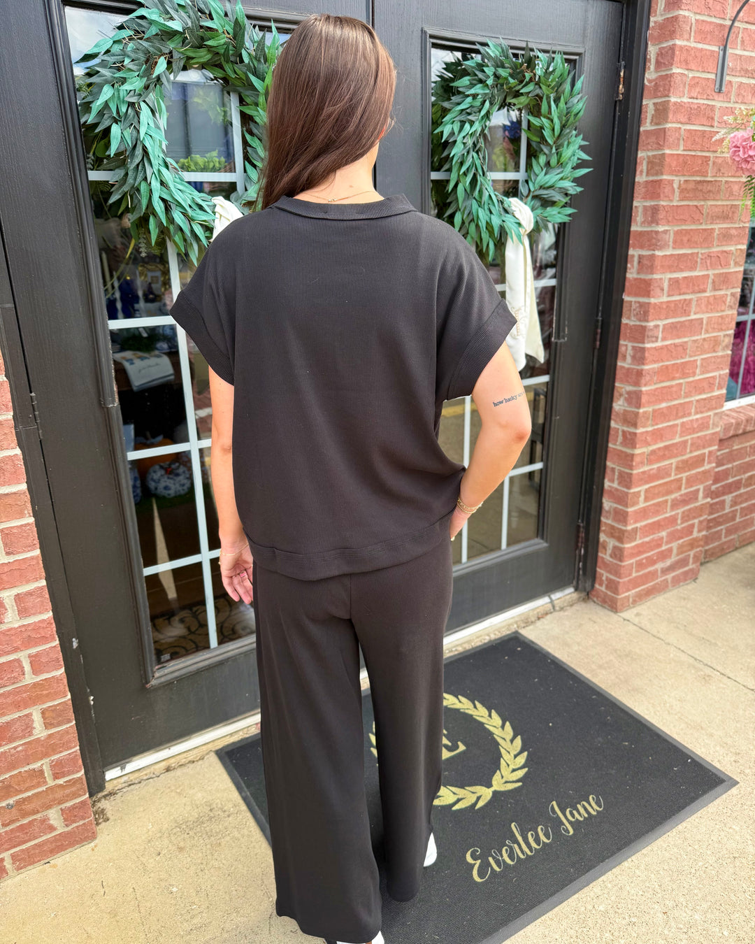 Scout Ribbed Set: black short-sleeved top and wide-leg trousers in ribbed fabric. Available in all sizes.