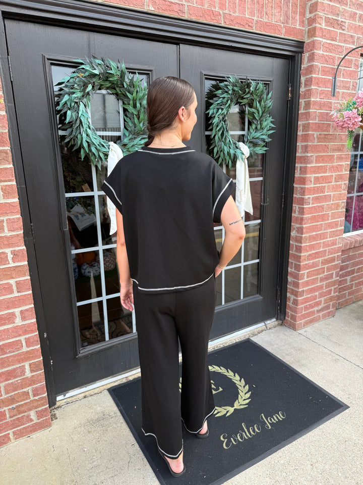 Black Contrast Stitch Scuba Lounge Set with short-sleeved top and wide-leg pants.