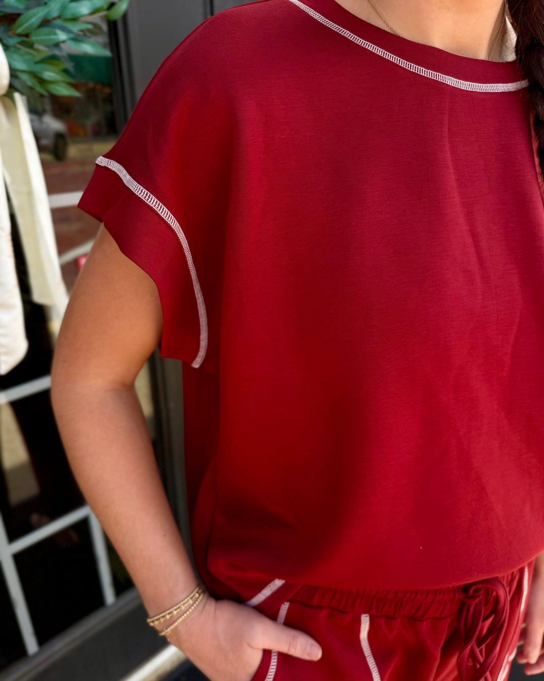 Red scuba lounge set with short-sleeved top, wide-leg shorts, and white contrast stitching. Available in multiple sizes.
