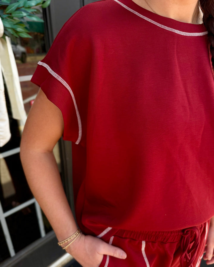Red scuba lounge set with short-sleeved top, wide-leg shorts, and white contrast stitching. Available in multiple sizes.
