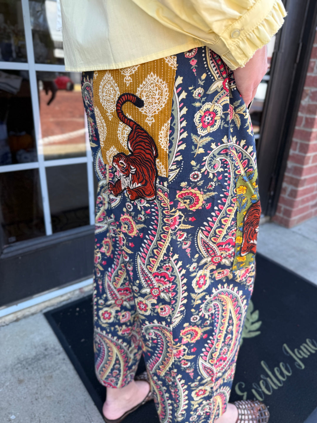 Loose-fitting Tiger Barrel Pant in dark blue paisley with mustard yellow patches and tiger illustrations. Sizes available: [Insert sizes].