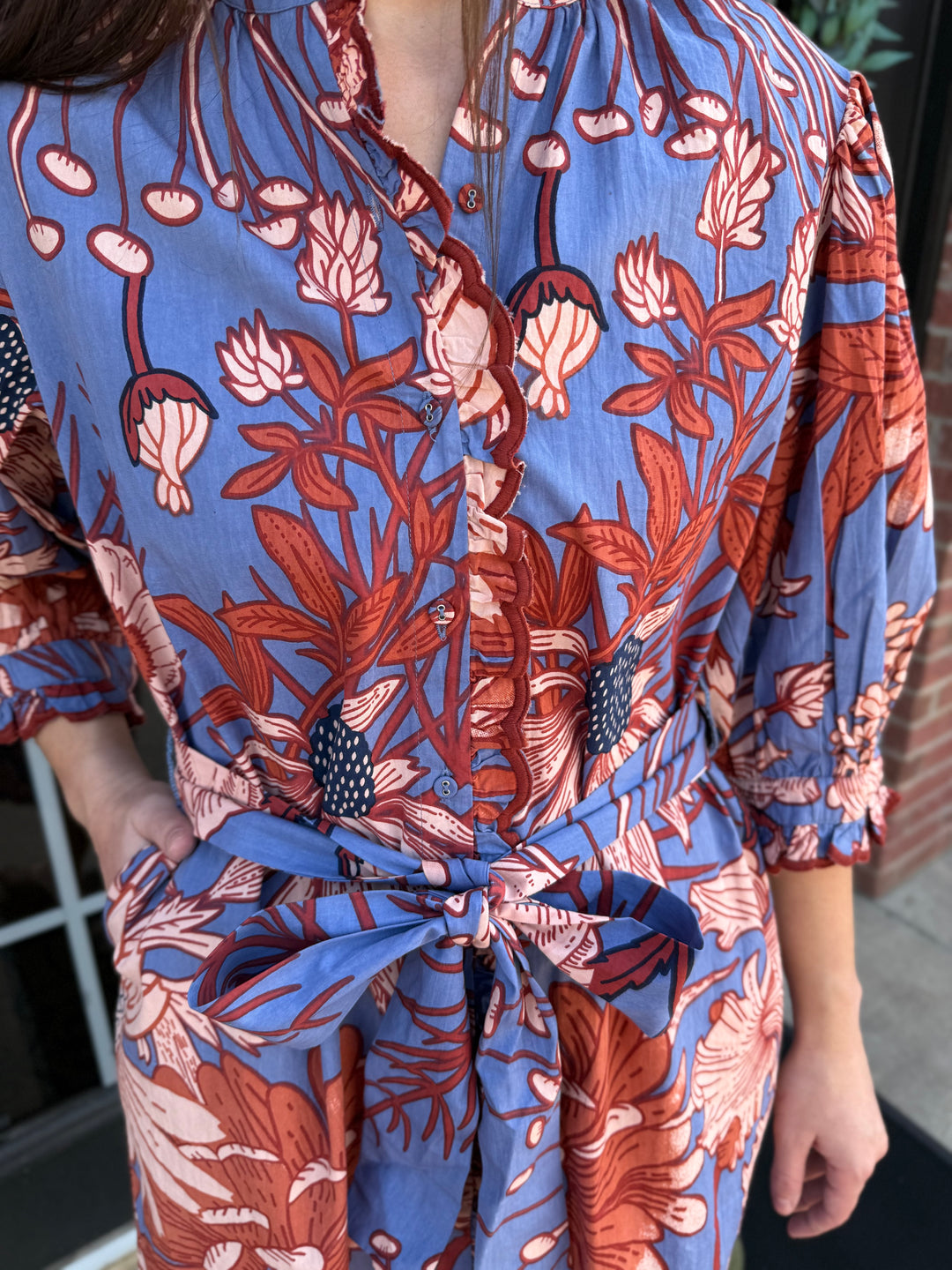 Blue floral midi dress with button-down front, scallop trim, and tie waist. Sizes available.
