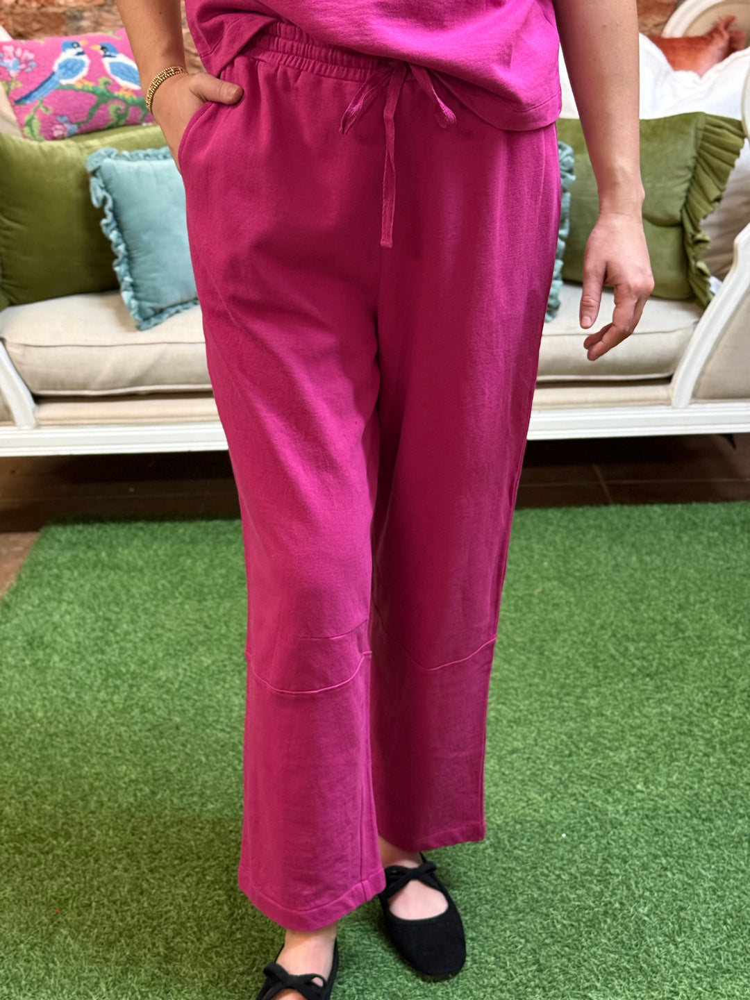 Fuchsia barrel-leg knit pants with elastic drawstring waist and knee seams.