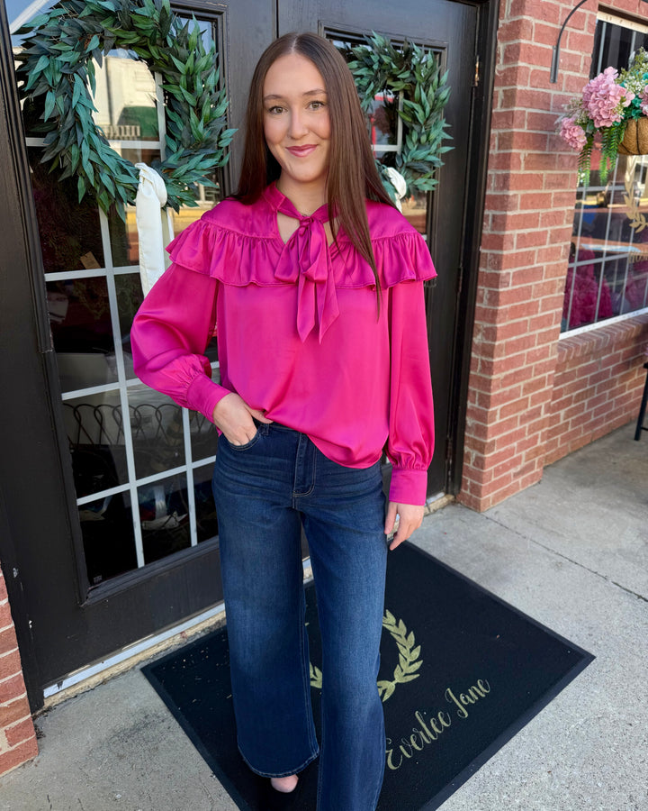 Fuchsia silky bow neck top with a ruffled collar. Available in sizes XS-XL.