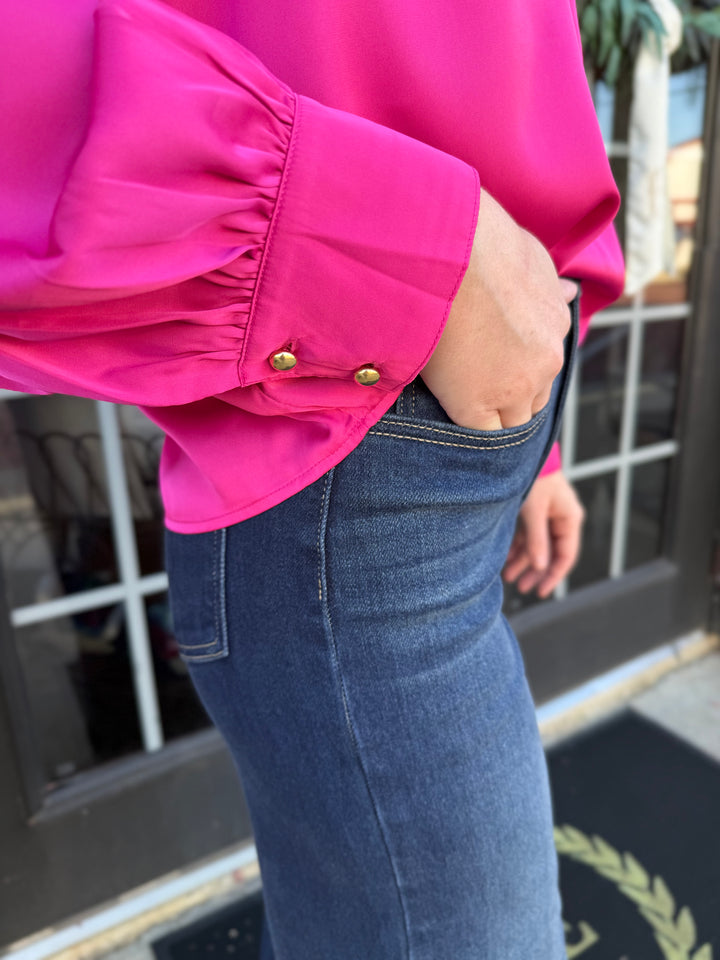 Fuchsia silky bow neck top with ruffle detail and buttoned cuffs. Sizes available.
