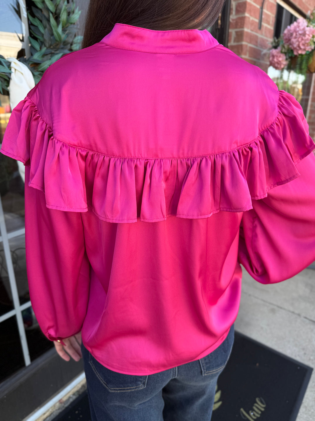 Back view of the fuchsia silky bow neck top with ruffled shoulder yoke and neck bow. Available in all sizes.