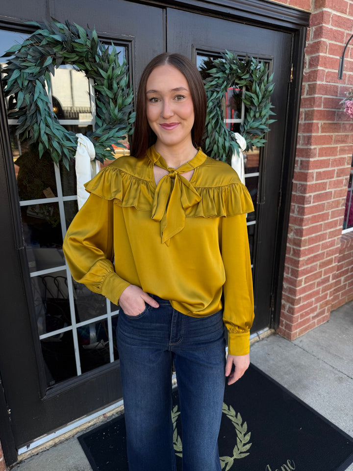 Chartreuse silky long-sleeve blouse with a ruffled yoke and a bow neck tie.