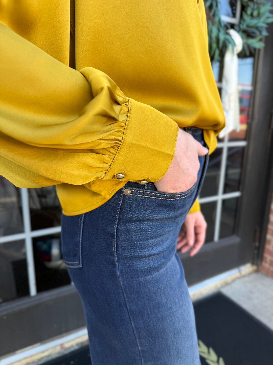 Chartreuse silky bow neck top with long sleeves and buttoned cuffs.