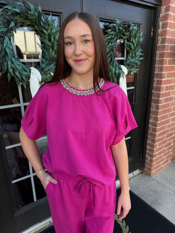 Fuchsia short-sleeve sparkle neck top with rhinestone-embellished round collar.