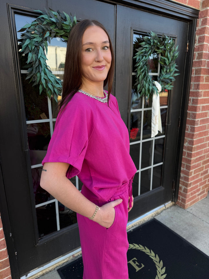 Fuchsia cotton top with short sleeves and crystal-embellished neckline. Available in sizes.