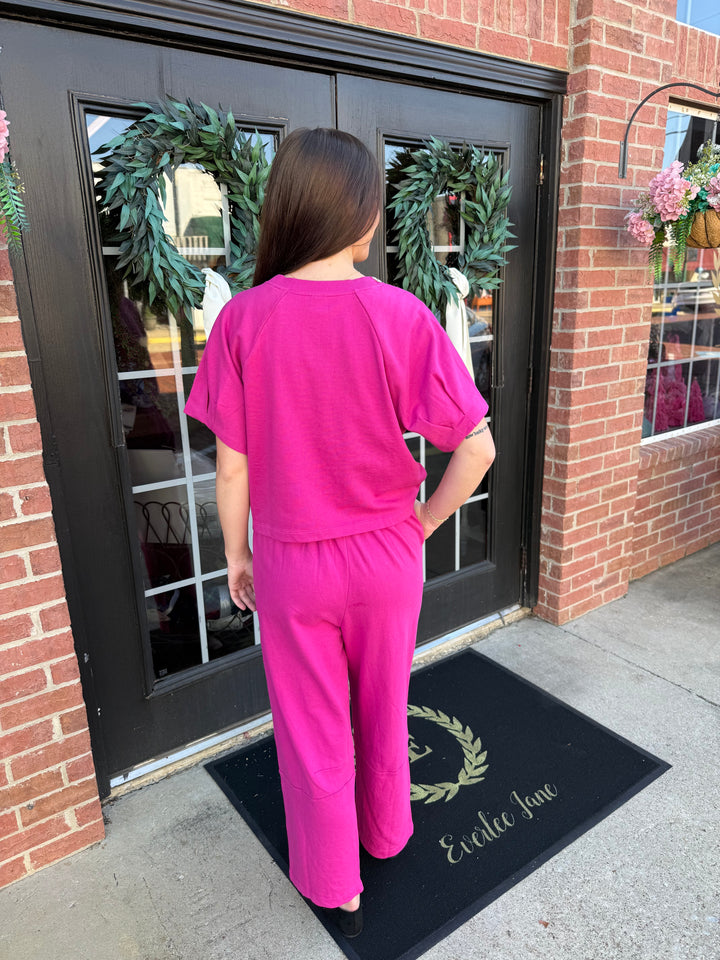 Fuchsia short-sleeve top with embellished neckline and matching wide-leg pants.