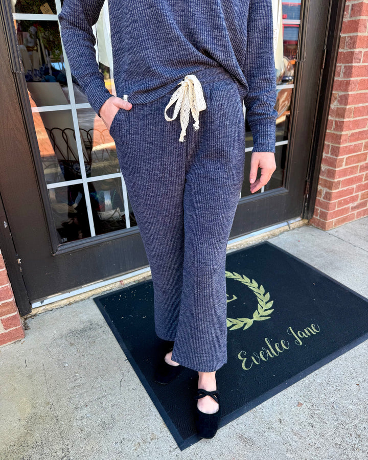Dusk Knit Cord Pant in dark blue. Ribbed knit, wide straight-leg, side pockets, cream drawstring elastic waistband. Available in all sizes.