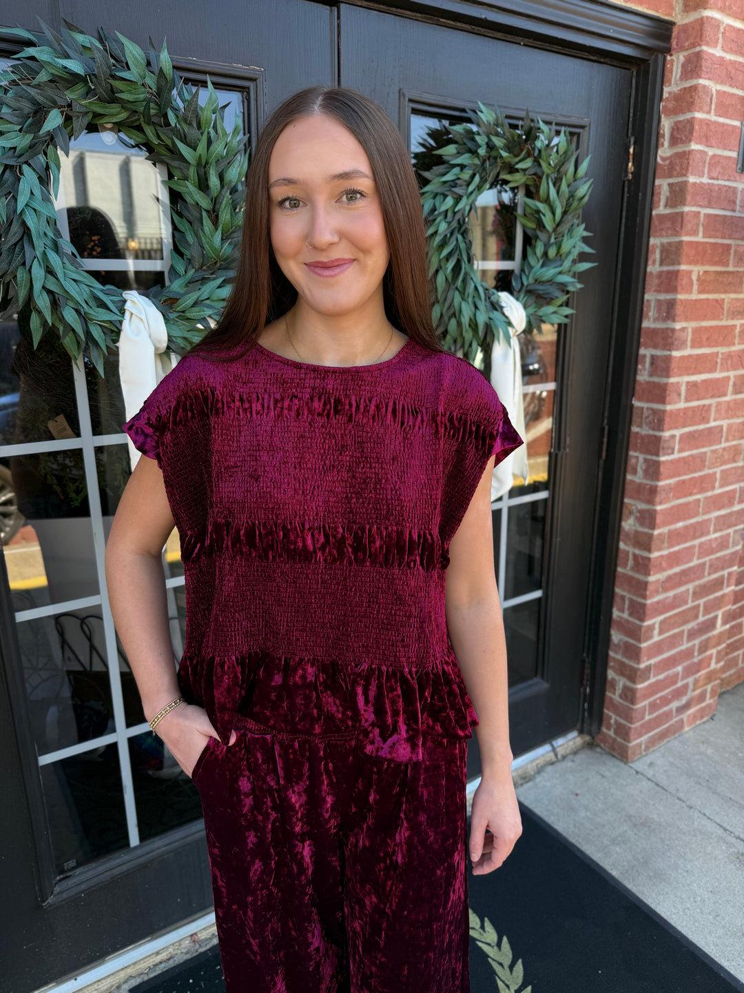 Dark red cranberry velvet short-sleeve smocked peplum top with a textured finish.
