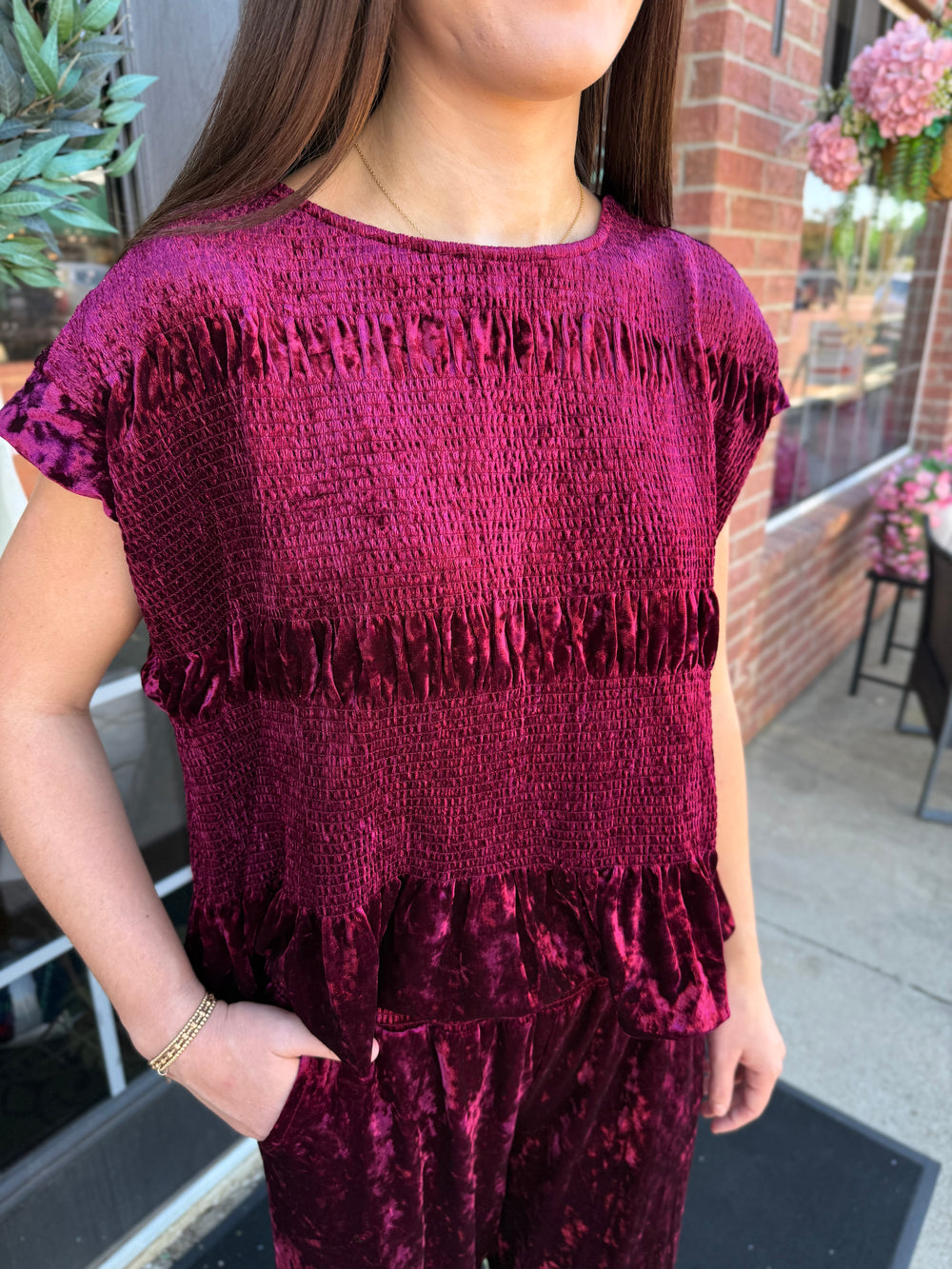 Cranberry velvet smocked peplum top with smocked bodice and peplum hem. Available in multiple sizes.