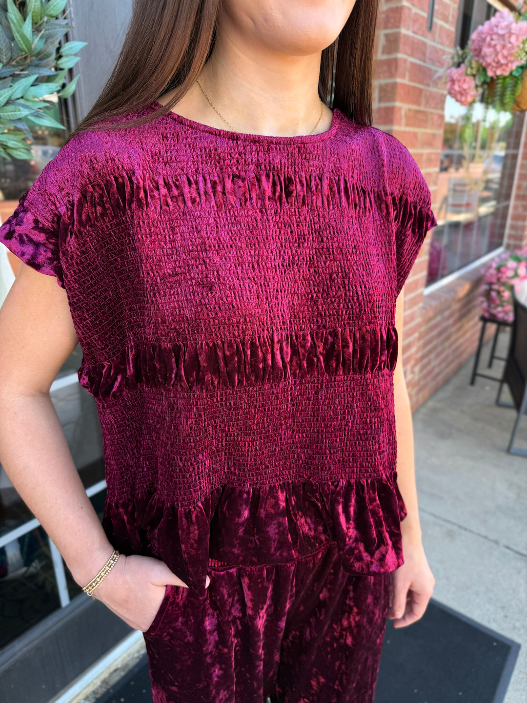 Cranberry velvet smocked peplum top with smocked bodice and peplum hem. Available in multiple sizes.