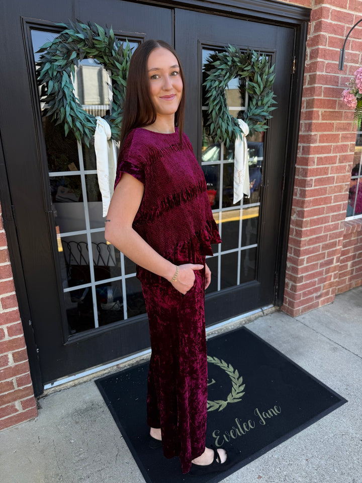 Cranberry velvet smocked peplum top with short sleeves and matching wide-leg trousers. Available in all sizes.