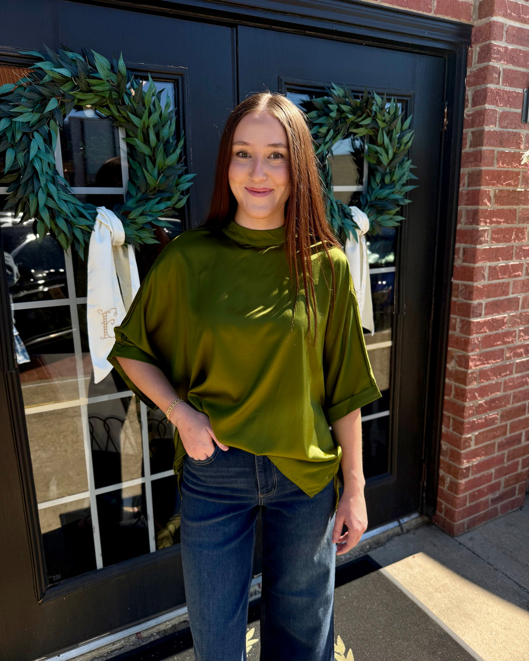 Olive green oversized satin mock neck top with short, wide sleeves and a high-low hemline. Available in various sizes.