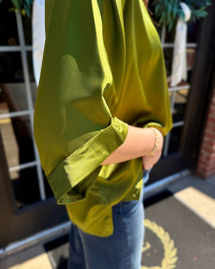 Olive green mock neck oversized satin top with short cuffed sleeves and a high-low hem. Available in sizes.