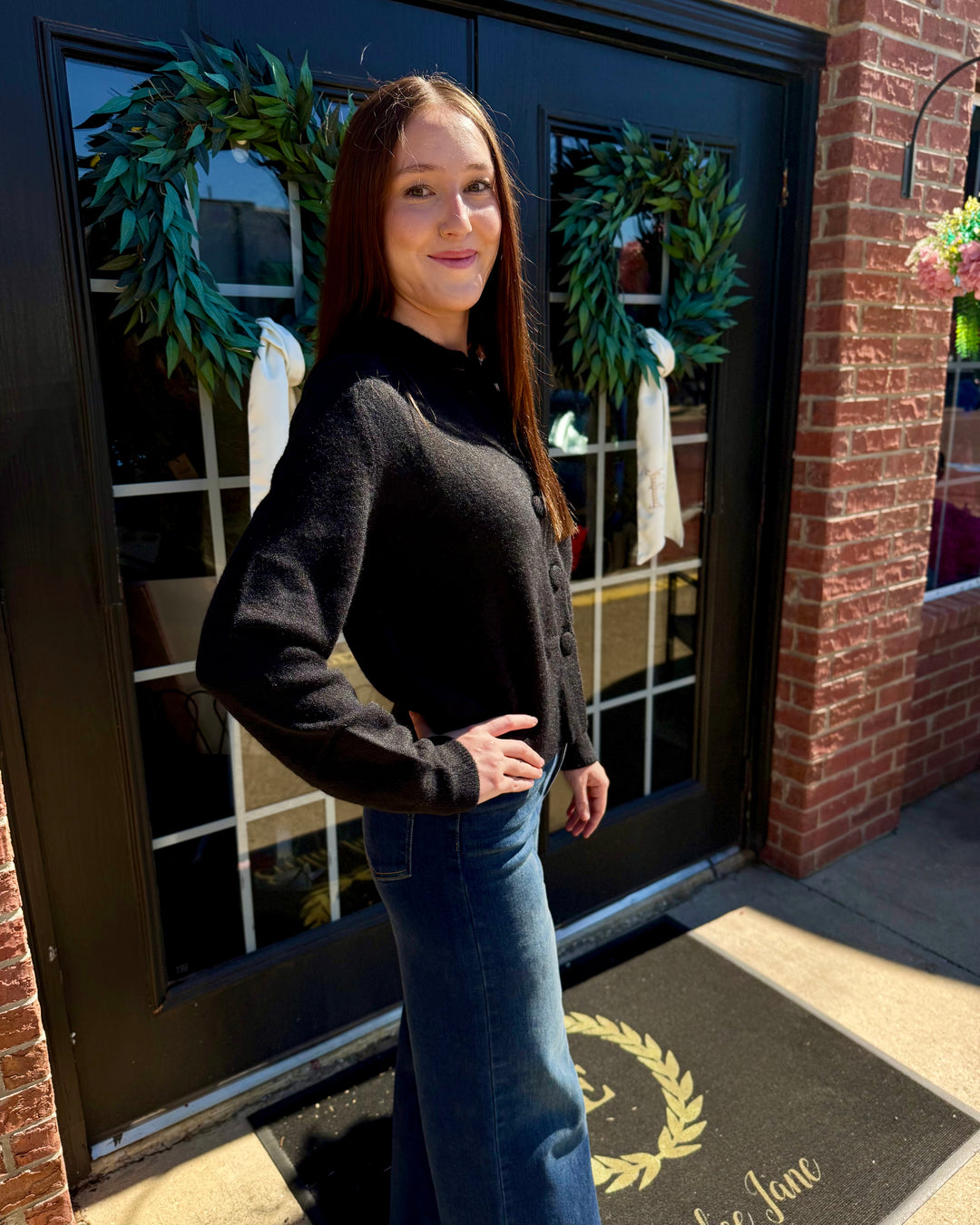 Black button-up cardigan, long-sleeve layering piece.