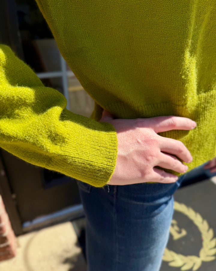 Lime green long-sleeve button-up cardigan with ribbed cuffs. Sizes available.