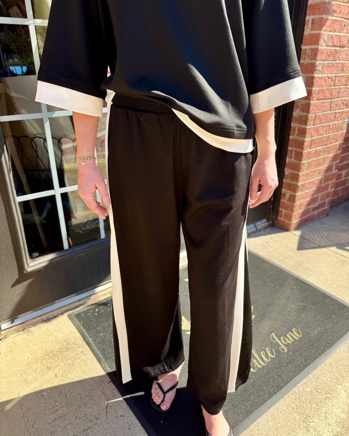 Black colorblock straight pants with white side stripe and elastic waistband. Available in all sizes.