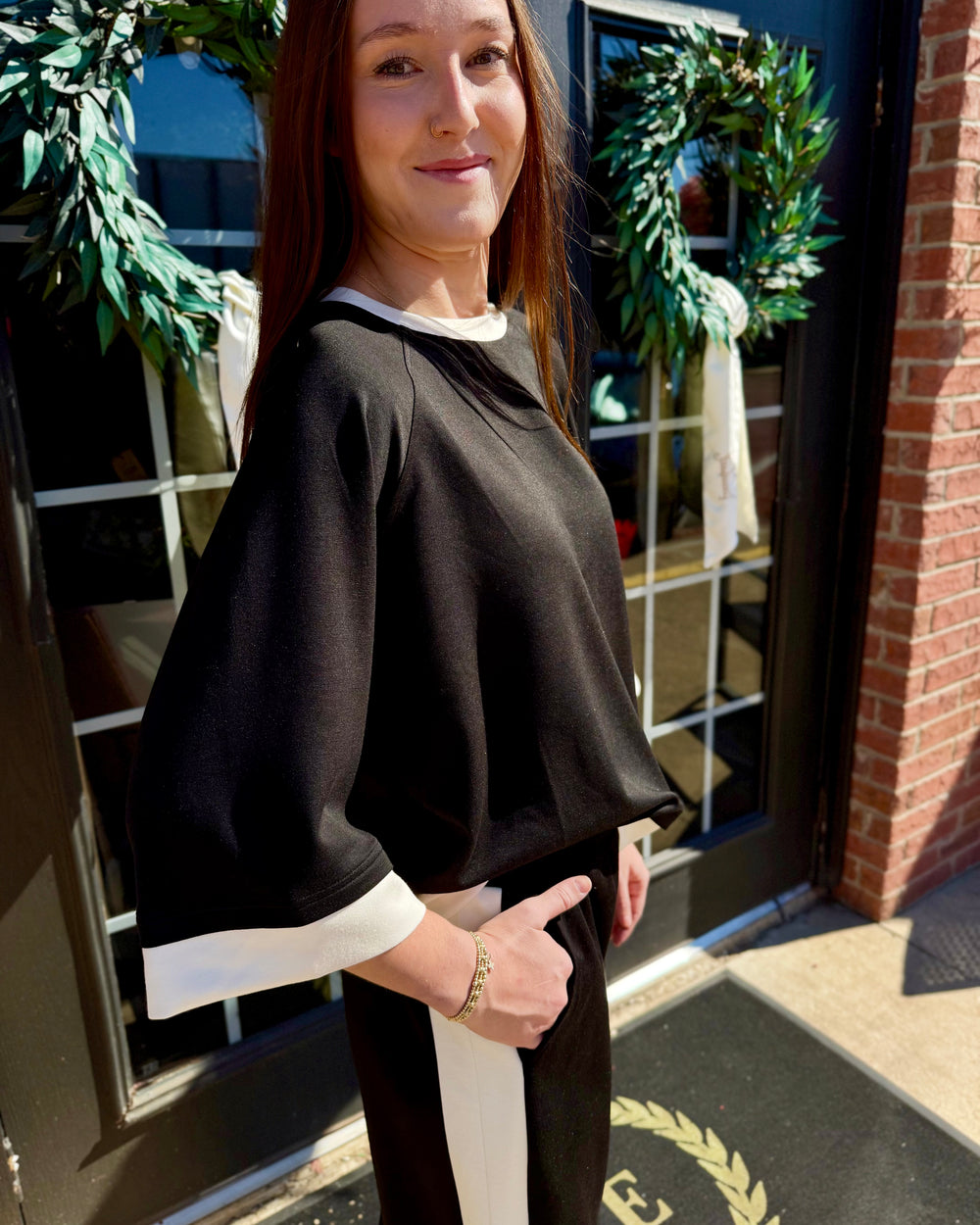 Black LuxeKnit colorblock raglan crewneck top with white trim at neck and cuffs. Available in all sizes.