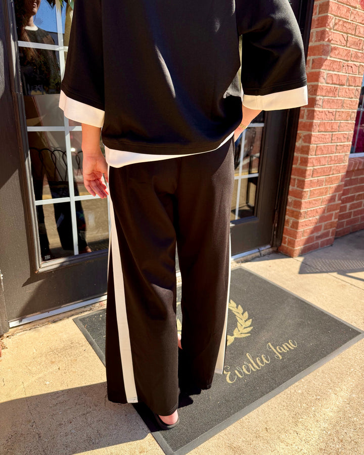 Black colorblock side-striped straight pants with white side stripe, available in multiple sizes.