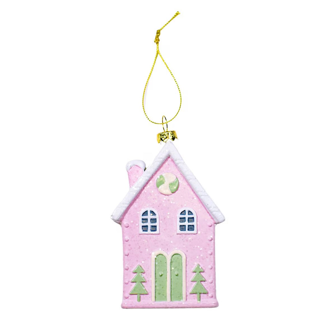 Winter Wonderland pink house ornament with snowy white roof, green doors, and gold hanging string.