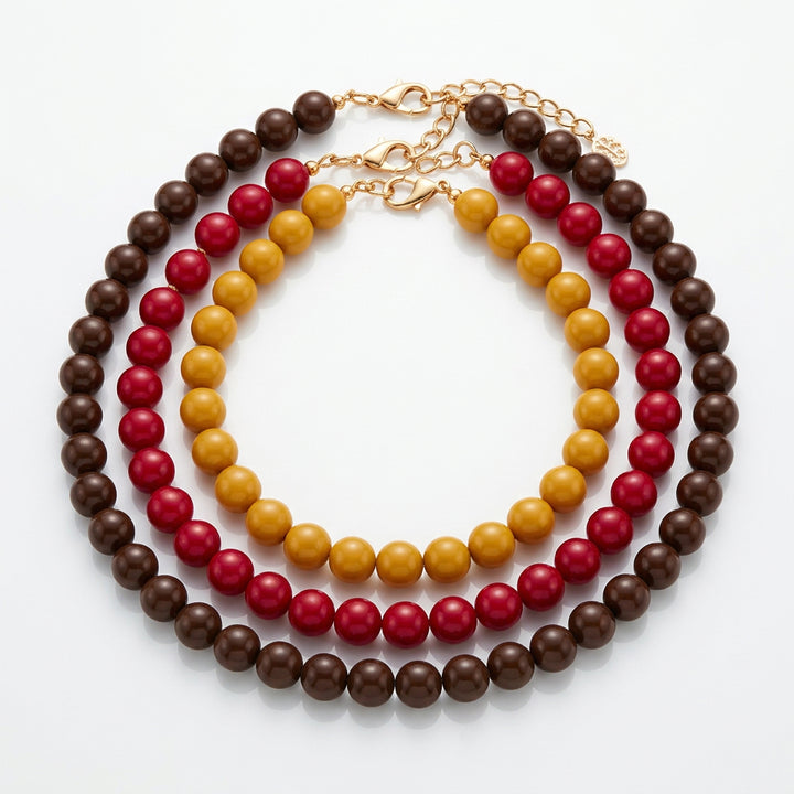 Sunset Beaded Necklace with three layered strands of brown, yellow, and magenta beads. Available in all sizes.