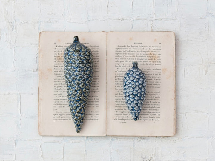 Two blue stoneware pinecone ornaments.