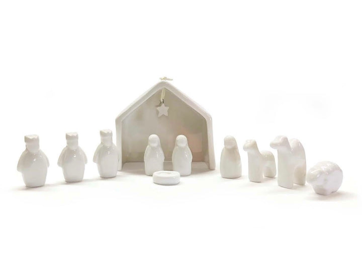 Miniature white ceramic Nativity scene figurines.