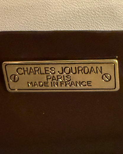 Metal label reading “CHARLES JOURDAN PARIS MADE IN FRANCE,” secured with two screws, on Vintage Charles Jourdan Paris Genuine Alligator Clutch. Sizes available: not specified.