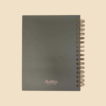 Dark gray scratch-resistant hardcover journal, gold wire binding, lined pages, "What's the Best That Could Happen"; multiple sizes.