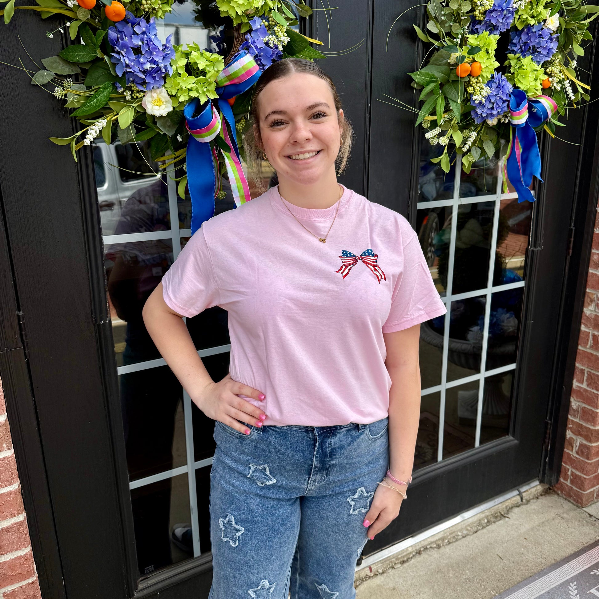 USA Cherry Bow SS T-Shirt for girls with small American flag bow. Available in sizes XS-XL. Perfect for Fourth of July.