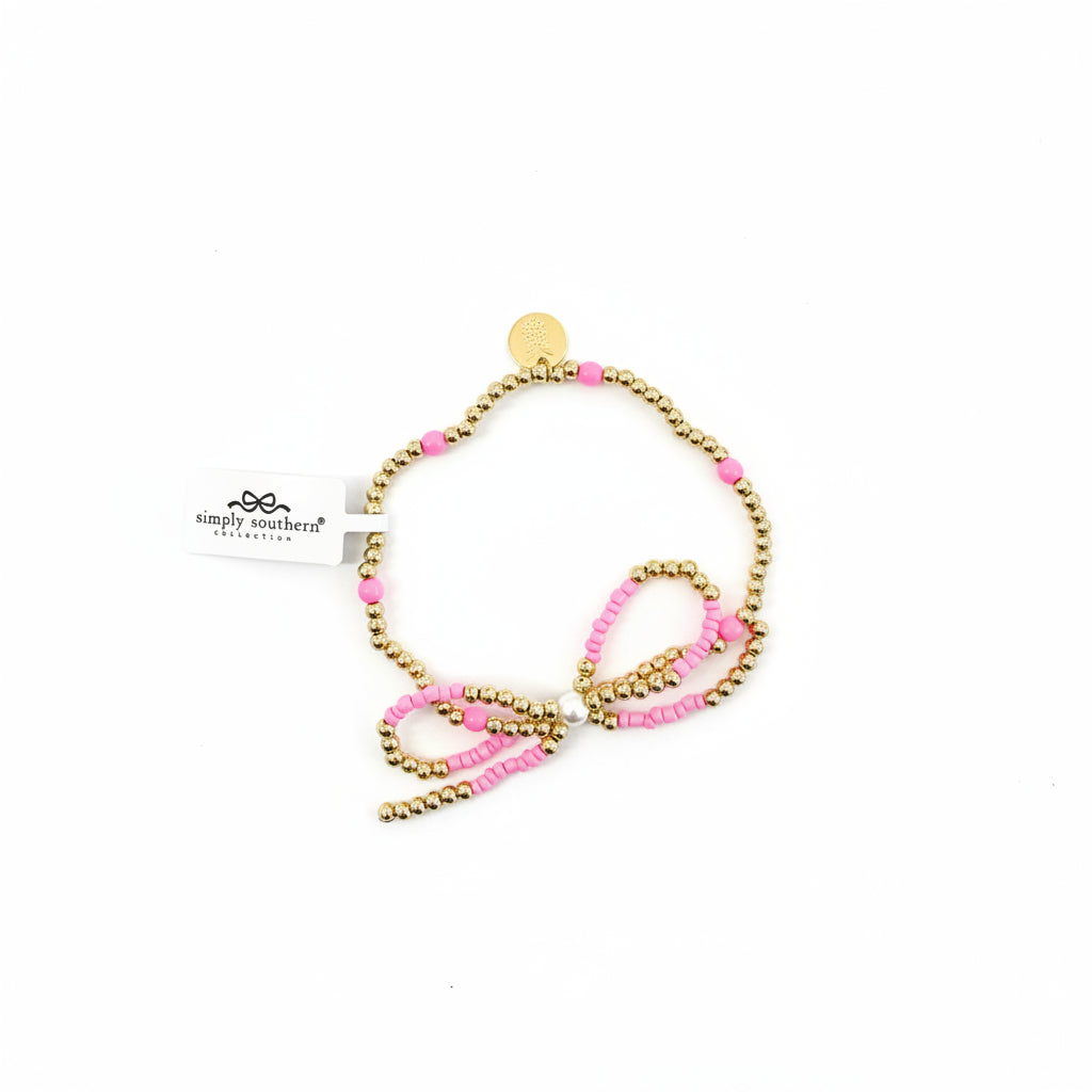 Gold beaded bracelets with pink accent beads, round gold charm, and “Simply Southern” tag. Available in S/M/L.