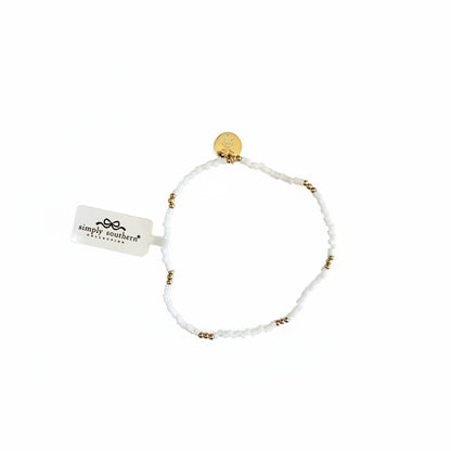 Gold beaded bracelets with white accent beads, gold charm, and "Simply Southern" tag. Available in S/M and M/L sizes.