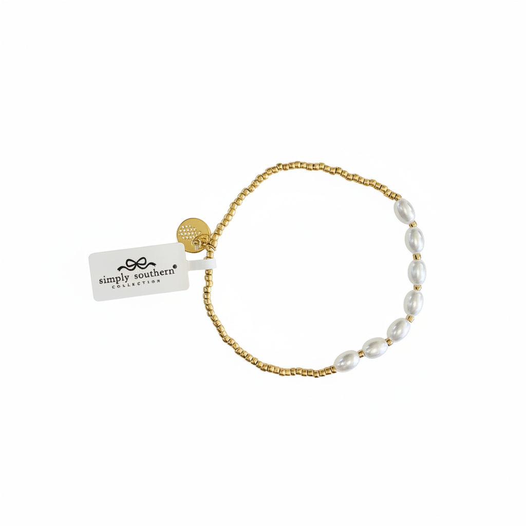 Gold beaded bracelet with white oval pearls, gold charm, and “simply southern collection” tag. Sizes: S/M, M/L.