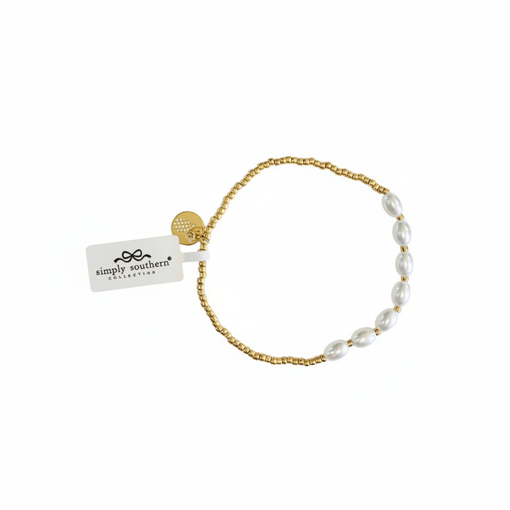 Gold beaded bracelet with white oval pearls, gold charm, and “simply southern collection” tag. Sizes: S/M, M/L.