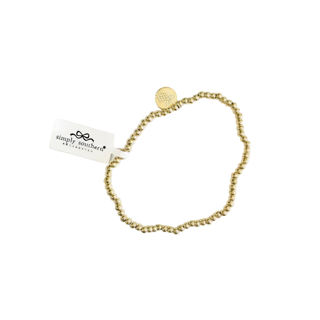 Gold beaded bracelet with accent beads, round charm, and white "simply southern" tag. Available in S/M and M/L sizes.