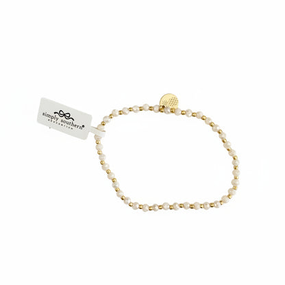 Gold beaded bracelet with alternating white beads, small gold charm, and "simply southern" tag. Available in S, M, L.